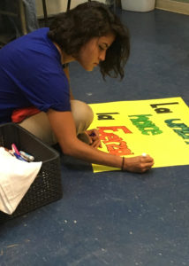 A volunteer with Casa Marinela prepares a sign for the Worker's Defense Project rally at a meeting on Tuesday, August 31.  
